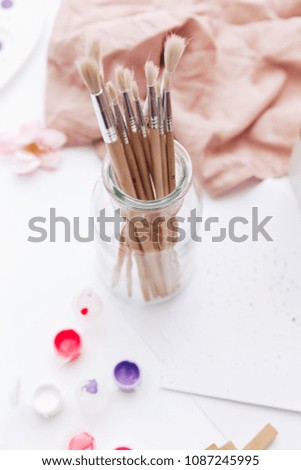 Paint brushes in bottle on light background 