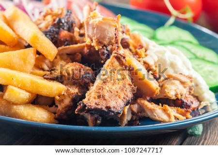 Greek gyros dish with french fries and vegetables. Served with tzatziki sauce