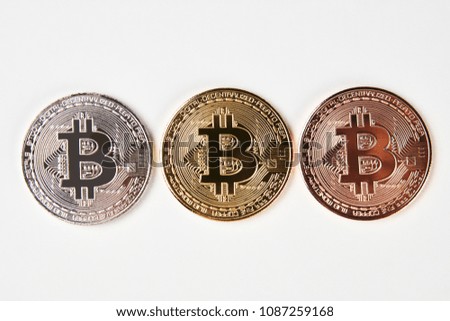 Bitcoins isolated on white background, close-up. Three bitcoin cryptocurrency coins made from gold silver and bronze metal