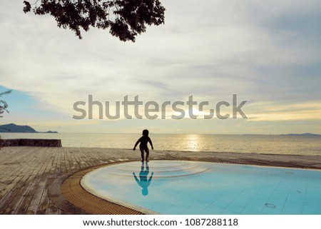 Swimming pool with sea view family travel and silhouette happy children playing on summer holiday