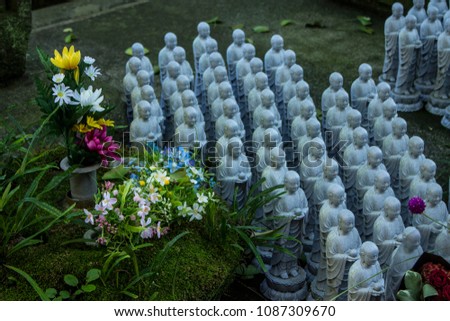 Buddha figures and flower offerings at the Hase-Dera temple in Kamakura, Japan