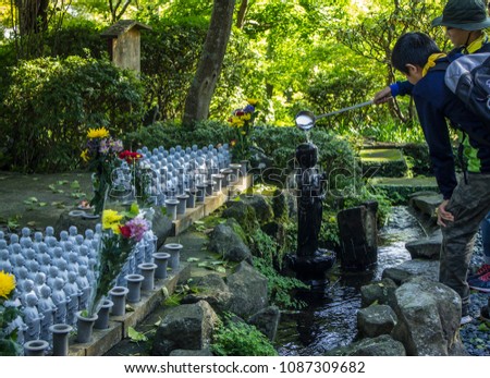Children making an offering at the temple of the baby Buddha Hase-Dera in Kamakura, Japan