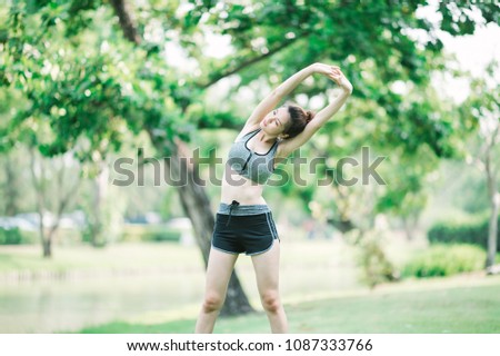 smile sporty woman standing in the park while her is cool down 