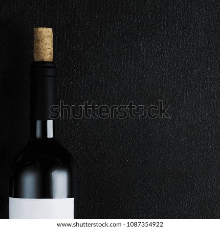 Bottle of wine with corkscrew on the black stone background, Wine degustation concept