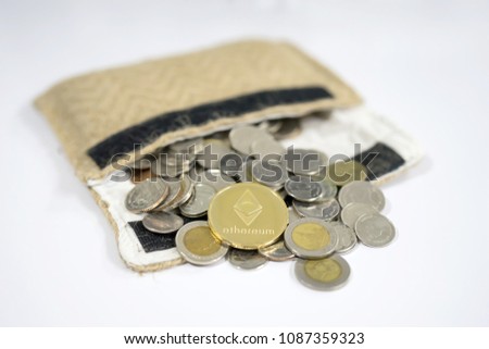 Business concept of back side of gold bitcoin on the Thai Baht coins stack being spread out of a brown sack