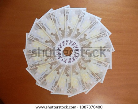 50 euro banknotes arranged in a circle on the desk to form a wheel