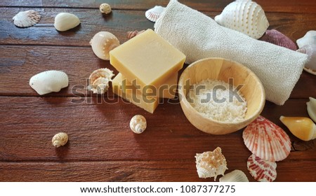 Handmade sea salt soaps bar and salt spa decoration with sea shells on wooden table .
