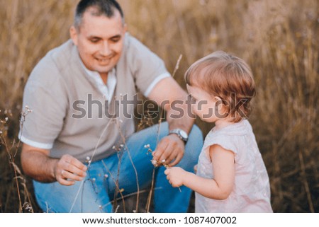 father and  daughter in a sunny summer field