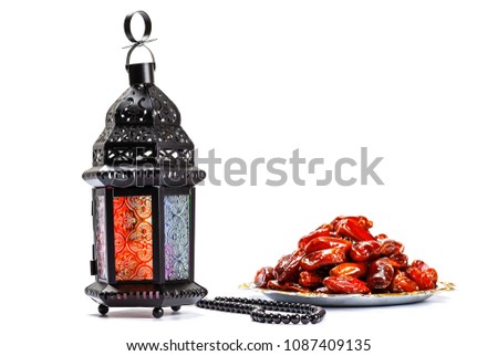The Muslim feast of the holy month of Ramadan Kareem. Beautiful background with a shining lantern Fanus and dried dates on white. Free space for your text Royalty-Free Stock Photo #1087409135