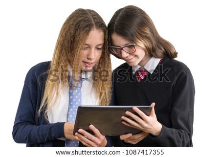 Happy high school friends closeup portrait. Teenage girls in school uniform on white background, with tablet, picture is isolated.