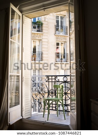 Beautiful Parisian balcony with a green chair, France