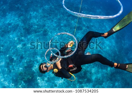 SCUBA diver blowing bubble rings over a coral reef
