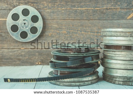 Stack of reels of old movies is on a wooden shelf
