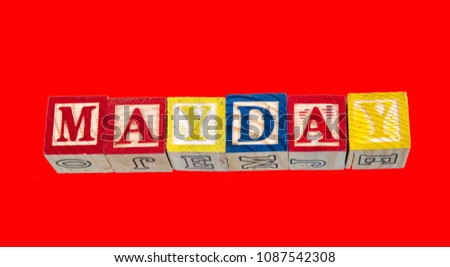 The phrase Mayday visually displayed on a red background using colorful toy blocks image with copy space in landscape format