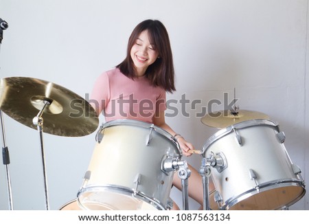 Teen girls are having fun playing drum sets in music class