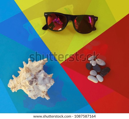 Sunglasses shell and stones on psychedelic yellow red and blue backgraund