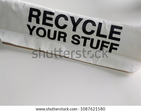 Recycle your stuff ,message on white calico bag on white background.Copy space.Recycle ,Eco,reuse concepts.Save the planet ,zero waste theme.