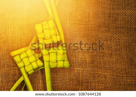 Ketupat (Rice Dumpling) On vintage jute cloth with artificial light effects. Ketupat is a natural rice casing made from young coconut leaves for cooking rice during eid Mubarak, Eid ul Fitr
