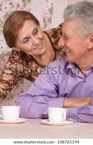 Beautiful older woman in a blouse with flowers and her husband