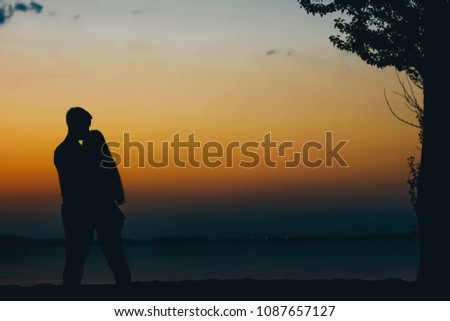 blurred background of a loving couple at sunset by the sea.