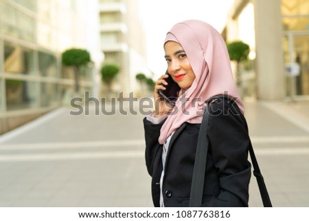 Veiled businesswoman and blurred building background with natural light.