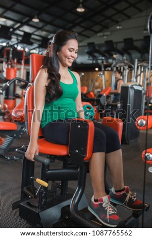 Attractive girl exercising her thighs in the gym