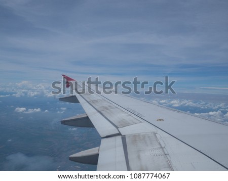 Commercial flight wing with blue sky background
