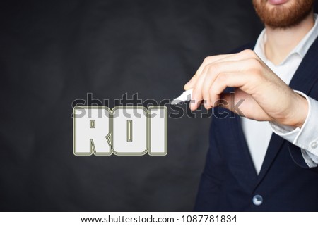 The businessman writes an inscription with a white marker:ROI