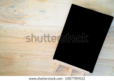 Top view of Small black empty chalkboard on wooden textured background. Blank Blackboard 