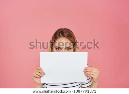 a woman hides behind a sheet of paper                             
