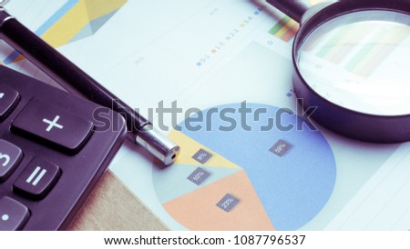 The concept of the company's sales analysis, charts and graphs looked through the magnifying glass.