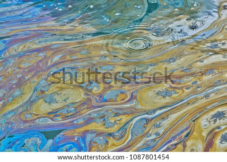 An environmental concern in a Texas bayou as a film of colorful oily pollutants cover the rippling, stagnant water. This can be the result of illegal dumping or factory runoff. Royalty-Free Stock Photo #1087801454