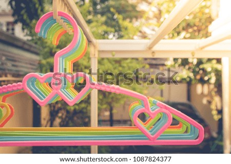 Rows of colorful clothes hanger on clothes line with green natural and sunlight in the background. (Selective focus)
