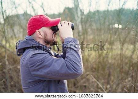 Man with the binoculars against the background of the nature. Observation of birds. Birdwatching