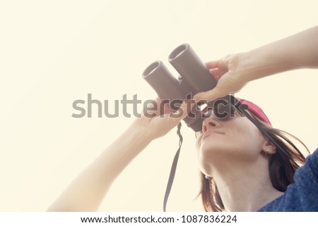Girl with the binoculars  against the sky. Observation of birds. Birdwatching Royalty-Free Stock Photo #1087836224