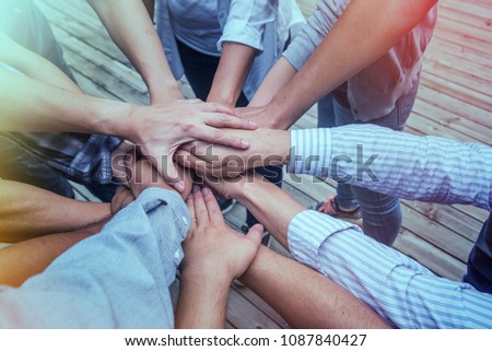 Volunteering, charity, people, gesture and ecology concept - group of friend  happy volunteers putting their hands together on a sunny day in park Royalty-Free Stock Photo #1087840427