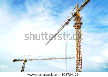 Industrial Construction cranes with blue sky and clouds background.Industry and Technology concept.                               