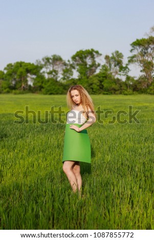 Beautiful girl with a poster in an open wheat field
