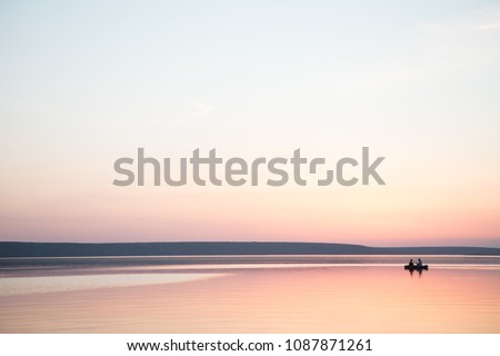 Couple in a boat in a lake or pond or river in a sunset calm water no wind summer minimalism silhouette people beautiful meditation tourism outdoor meditation life happiness