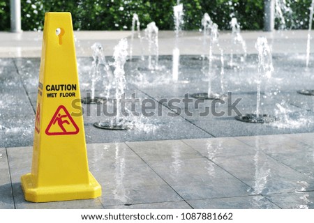 Caution wet floor sign. Warning symbol of slippery floor from fountain. Sign and symbol concept.