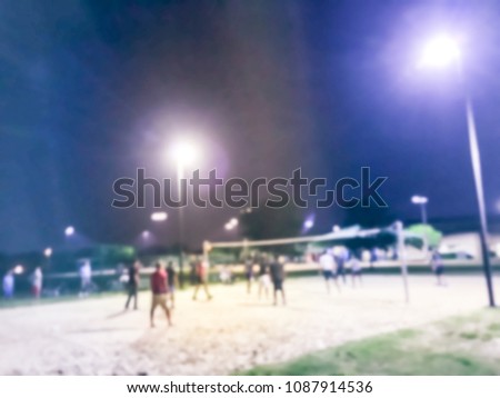 Vintage blurred motion volleyball players in action on open air court at evening. Abstract Indian men group playing on sand volleyball court near light pole at public park in Irving, Texas, USA