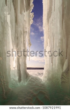 The sun peeks through ice columns on Lake Superiors Grand Island, near Munising Michigan