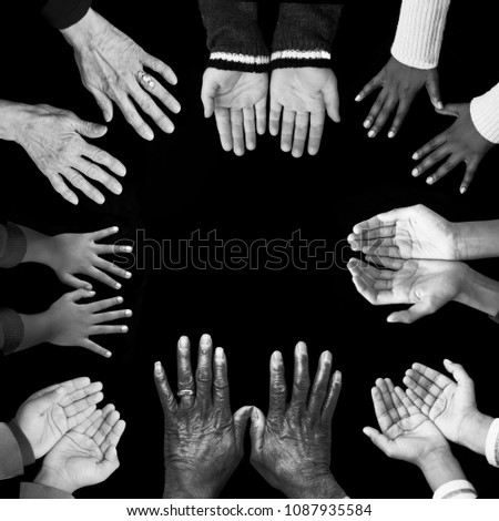 Eight diverse, unique sets of hands reach into the image, bordering a solid black square background. Young and old, diverse in color, size and age. Black, Caucasian, Indian and Asian skin colors.