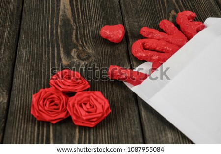 White envelope, word Love, heart and three roses on wooden background