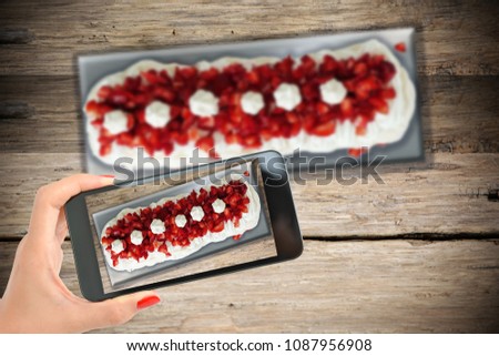 Take smartphone picture of a perfect Pavlova cake with meringue, cream and strawberries
