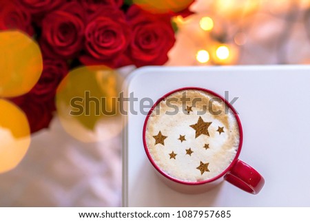 cappuccino with a picture of stars and red roses