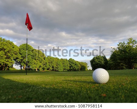 Golf green with flag and ball, Chorleywood Common Royalty-Free Stock Photo #1087958114
