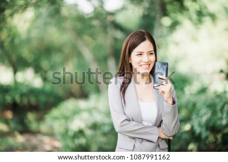 Happy business woman hold smartphone while her talk with friend 