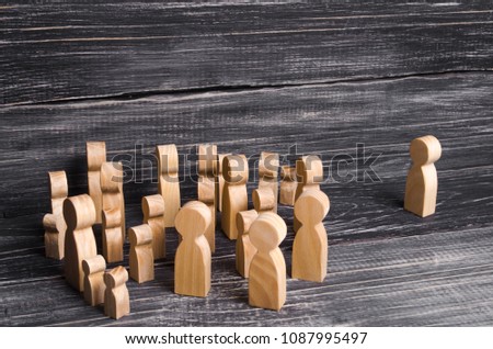 A crowd of people is standing and looking at a lonely man standing. People follow the leader, the boss. Hearings, forum, rally. Expulsion of a person from the collective. Propaganda, listening Royalty-Free Stock Photo #1087995497
