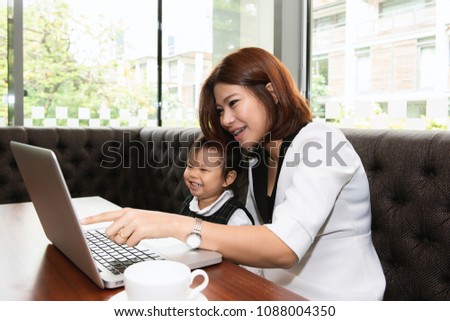Relationship of asian mother and daughter concept. Mom and little girl using laptop computer to play game togethers in weekend at home.